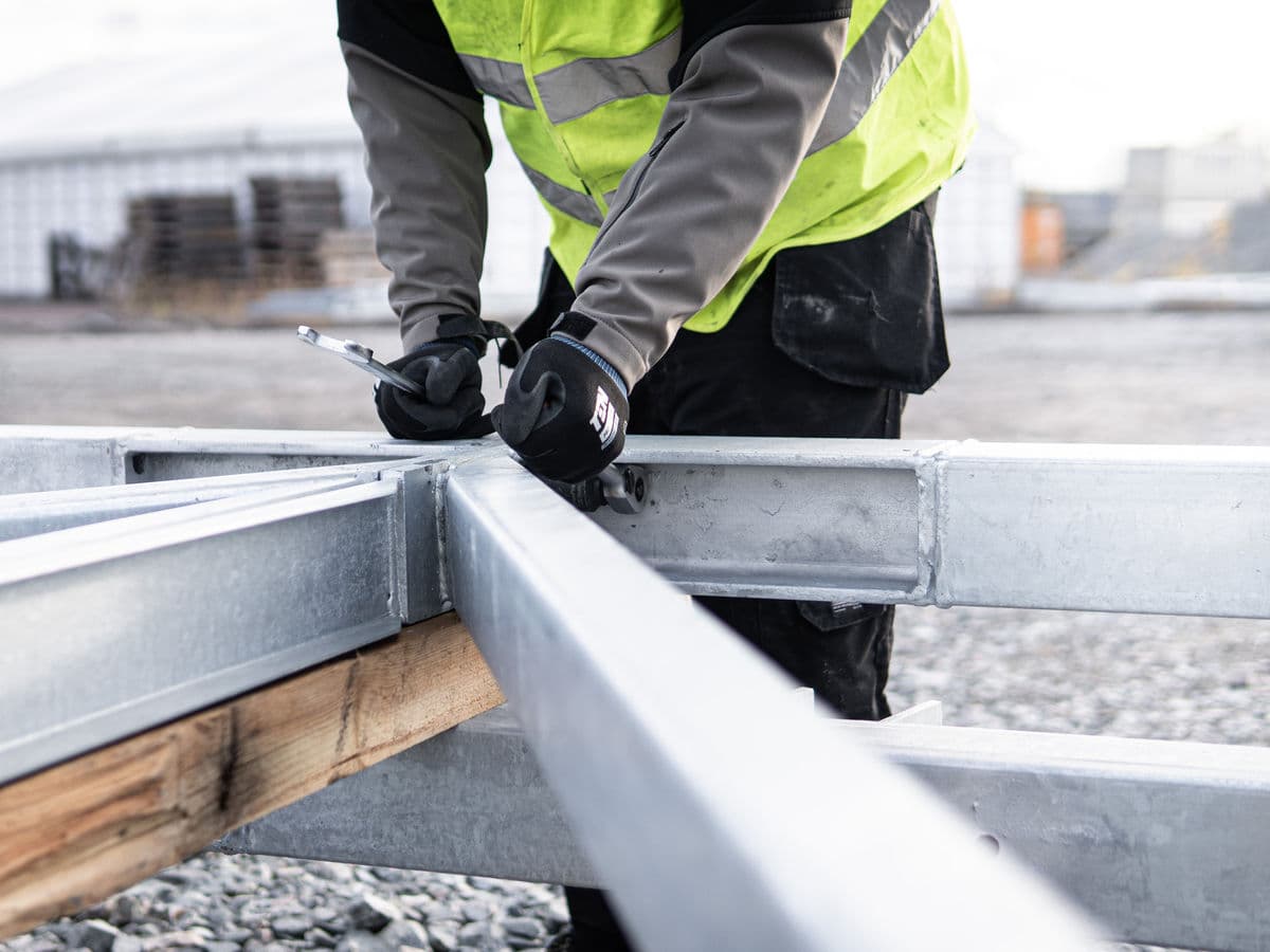Construction worker bolting steel building framing together.